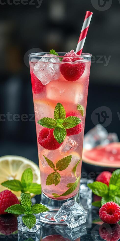 Refreshing raspberry lemonade cocktail served with mint leaves and ice in a tall glass photo