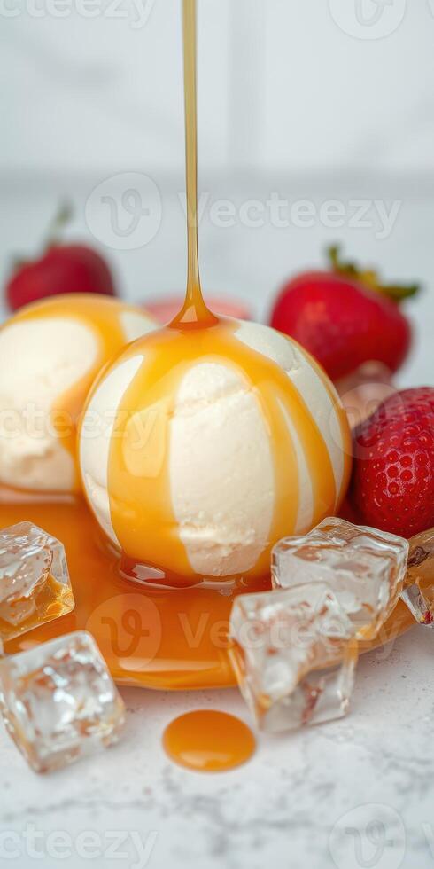 Delicious vanilla ice cream topped with caramel syrup and fresh strawberries on a marble countertop photo