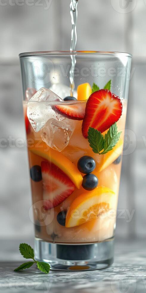 Refreshing fruit-infused drink prepared with fresh strawberries, blueberries, and citrus slices in a clear glass photo