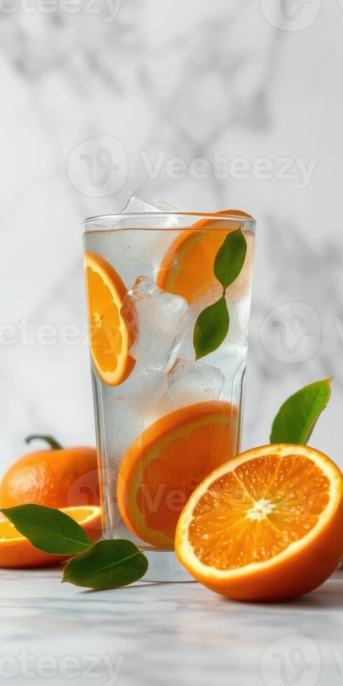 Refreshing orange beverage with slices and leaves arranged beautifully on a marble surface photo
