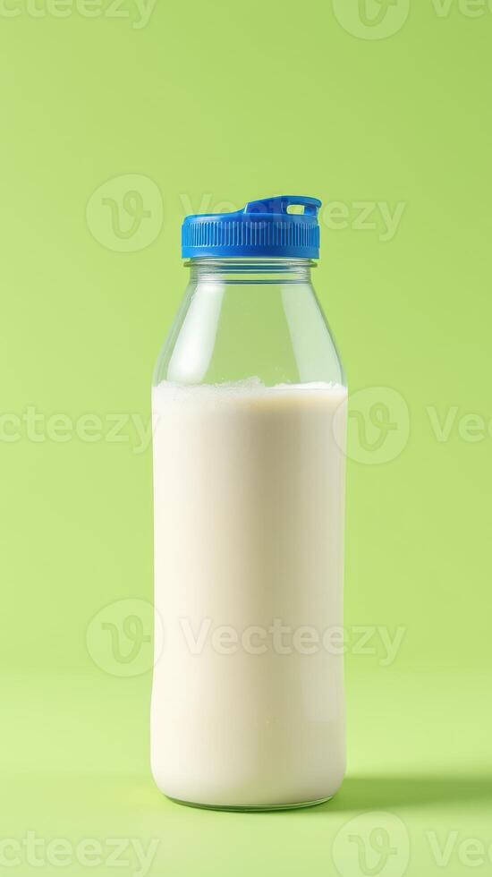 Fresh milk in a clear bottle against a vibrant green backdrop ready for consumption photo