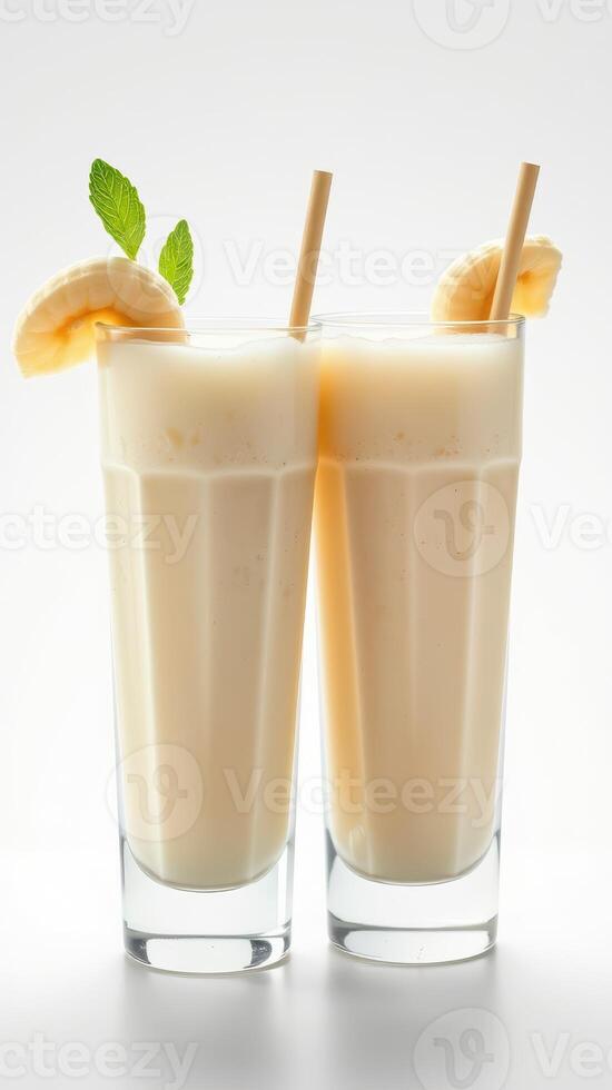 Creamy banana smoothies served in tall glasses with mint garnish and straws for a refreshing drink photo
