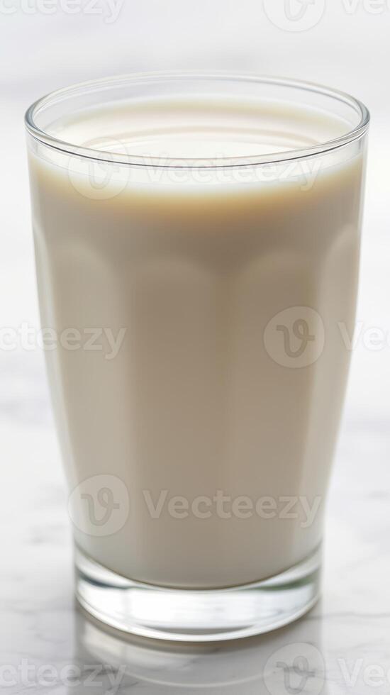 Smooth and creamy glass of milk served on a marble countertop in a cozy kitchen setting photo