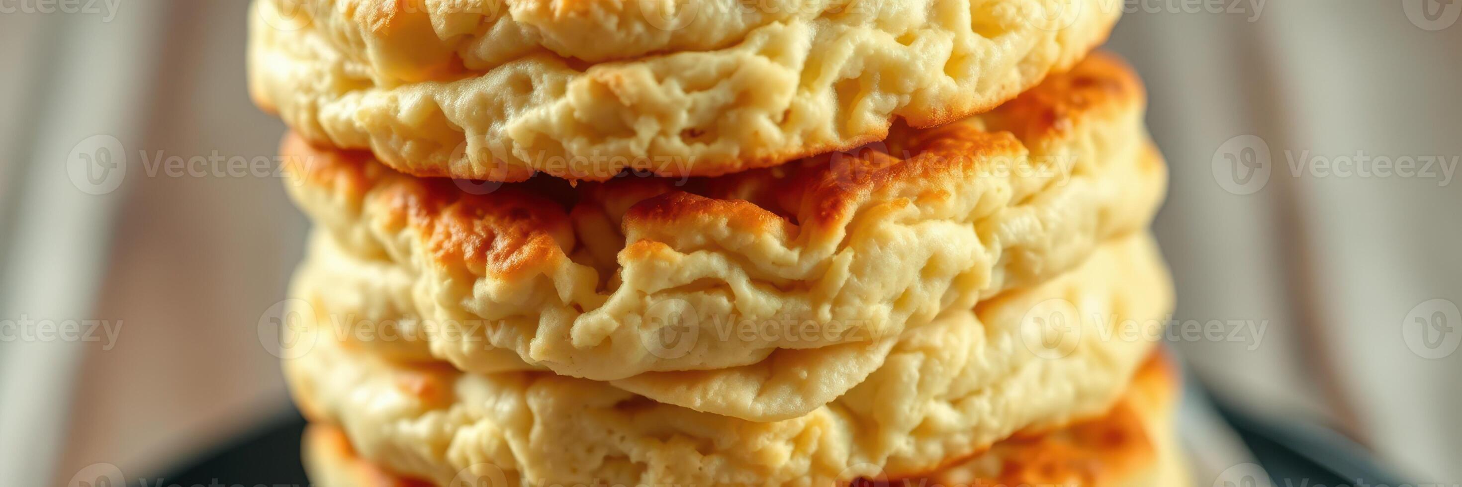 Freshly made fluffy biscuits stacked high on a plate, showcasing their golden brown tops and soft texture photo