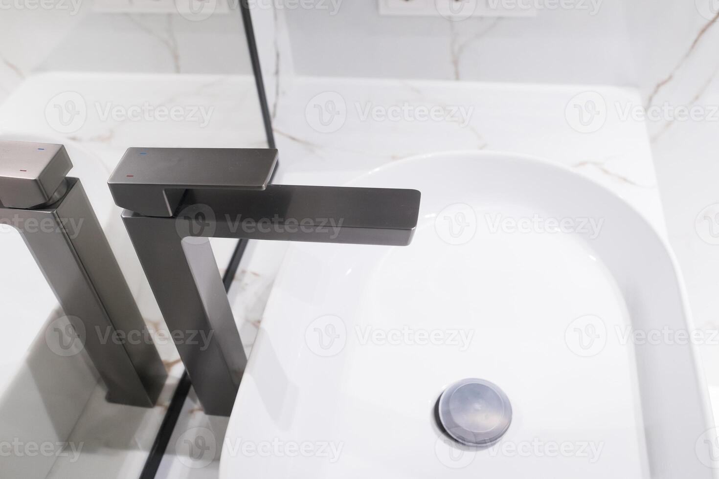 Stylish deluxe water faucet and white countertop sink in bathroom. Stylish bathroom photo