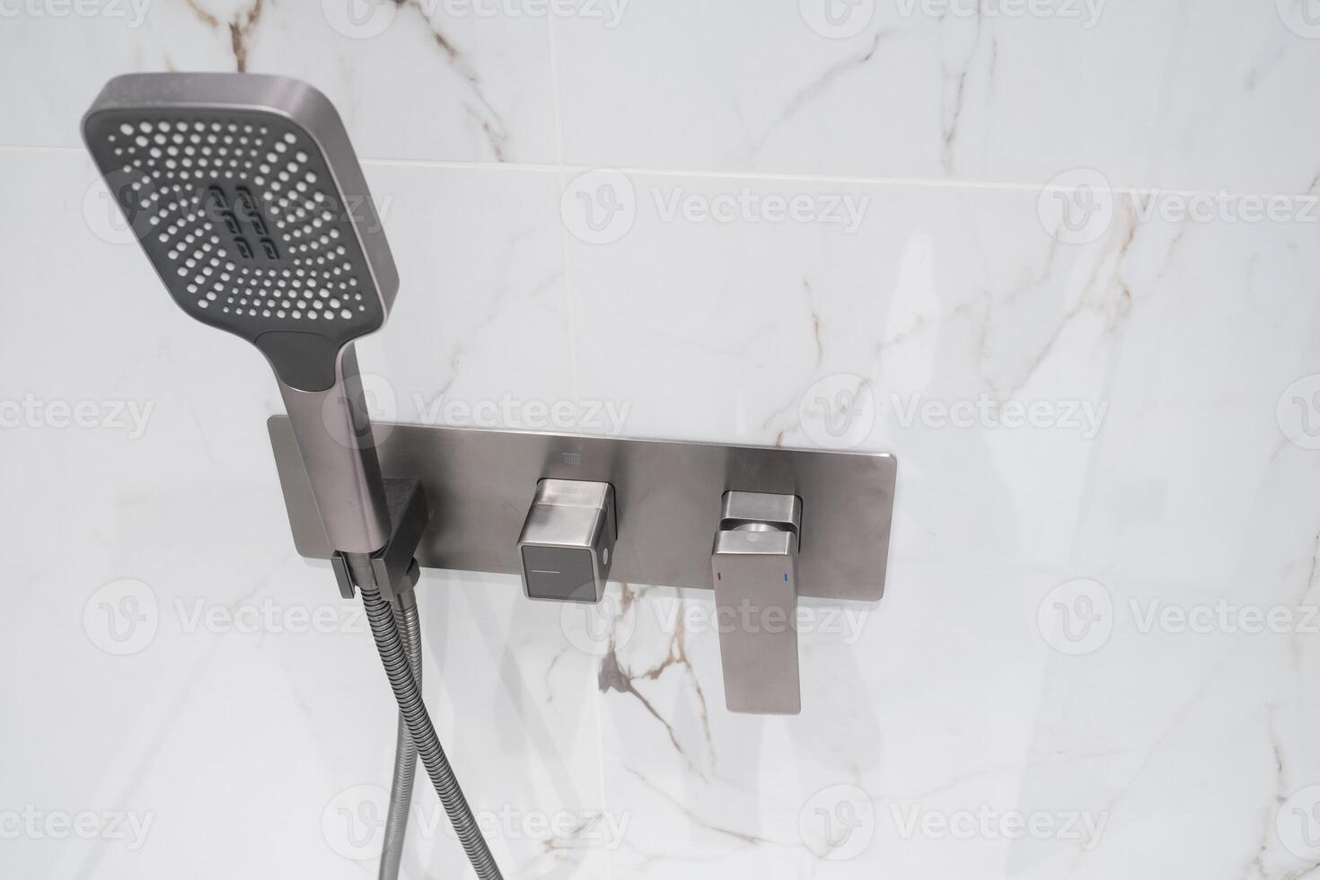 New stylish faucet and shower in shower enclosure with white granite walls. Modern luxury shower cubicle photo