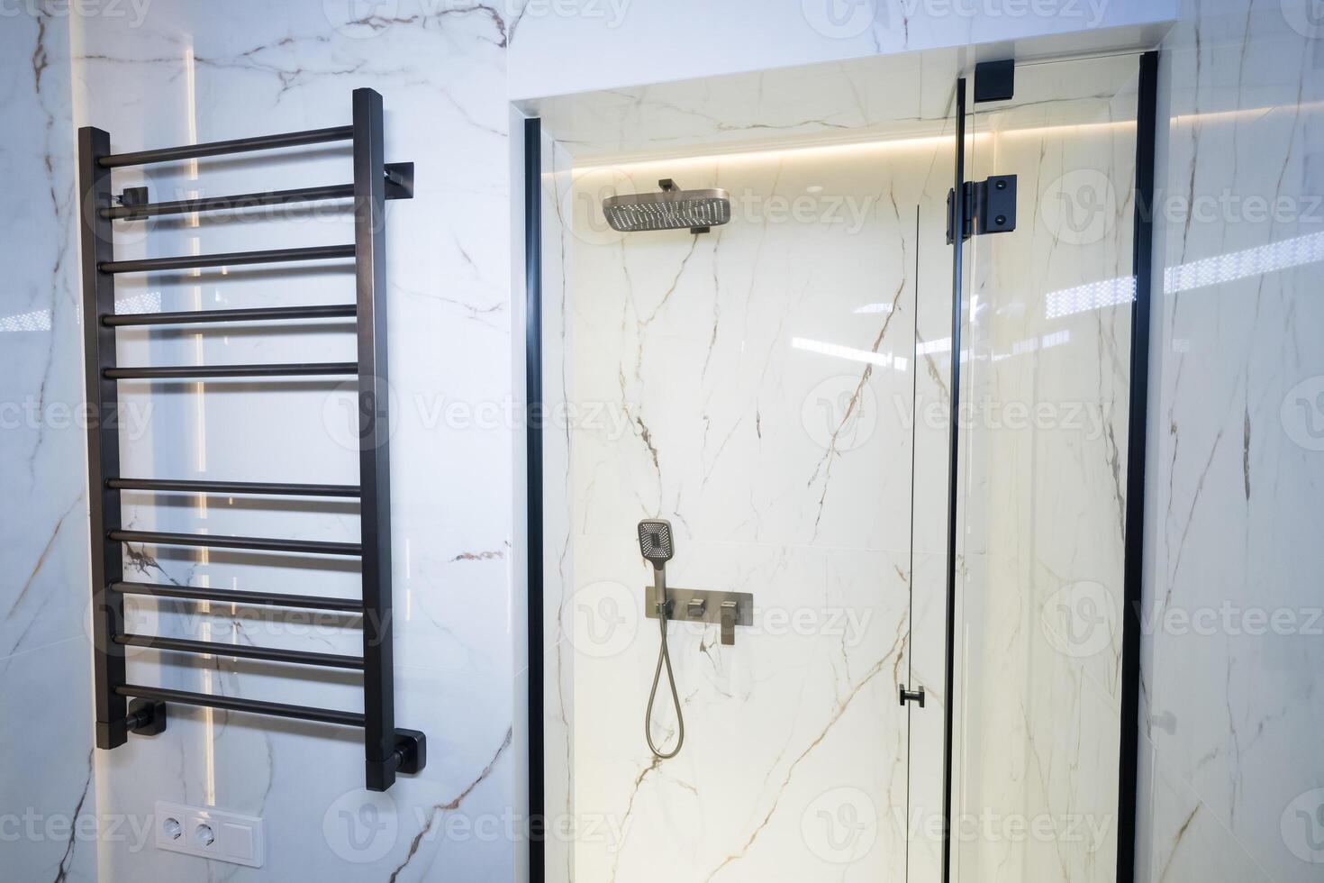 Modern black radiator on white marble wall in bathroom. New bathroom with granite white tiles photo