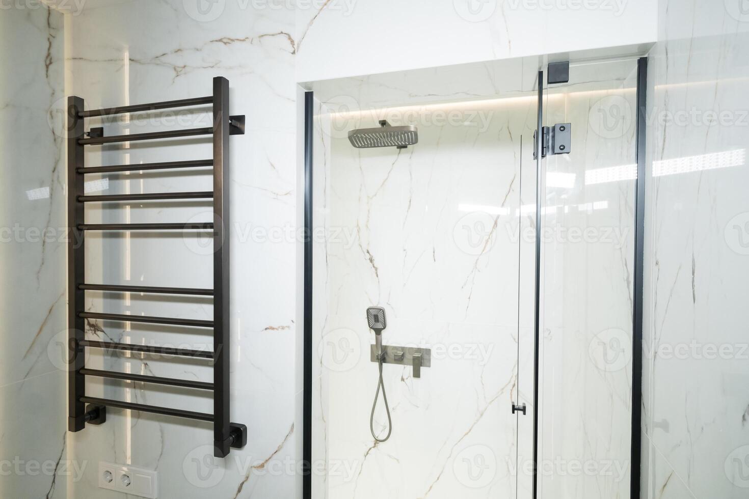 Modern black radiator on white marble wall in bathroom. New bathroom with granite white tiles photo