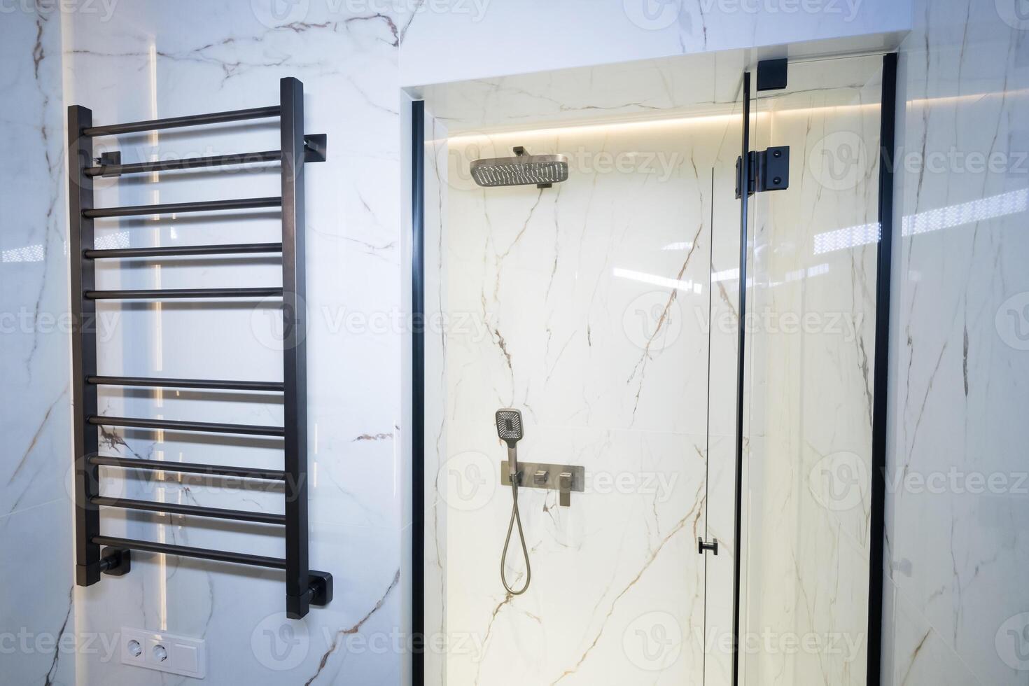 New stylish faucet and shower in shower enclosure with white granite walls. Modern luxury shower cubicle photo