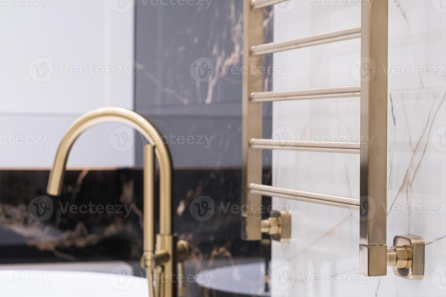 gold-colored heating radiator on a granite wall in the bathroom photo