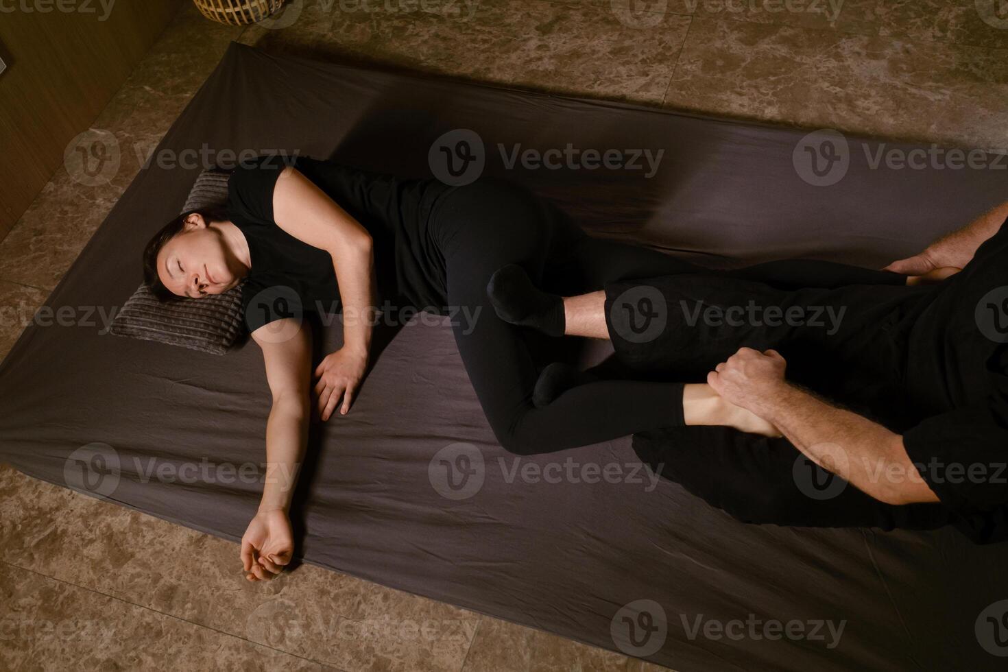 Girl in Thai massage session from therapist in massage room . Traditional Asian stretching therapy photo