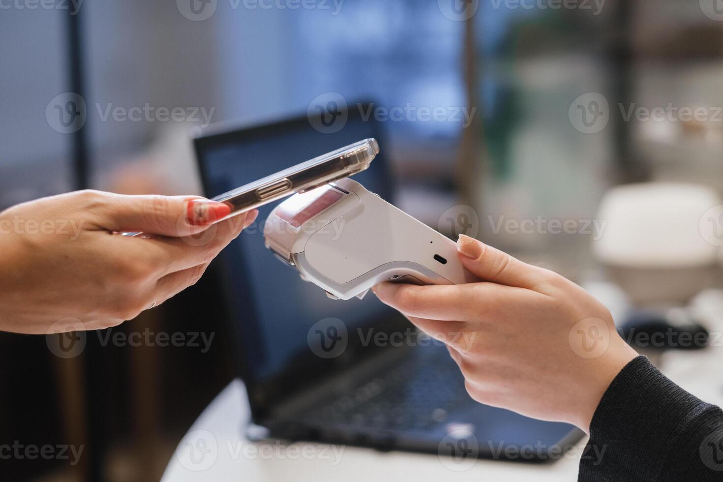 A customer uses his phone to pay through a terminal . Concept of cashless technologies and money transfers photo