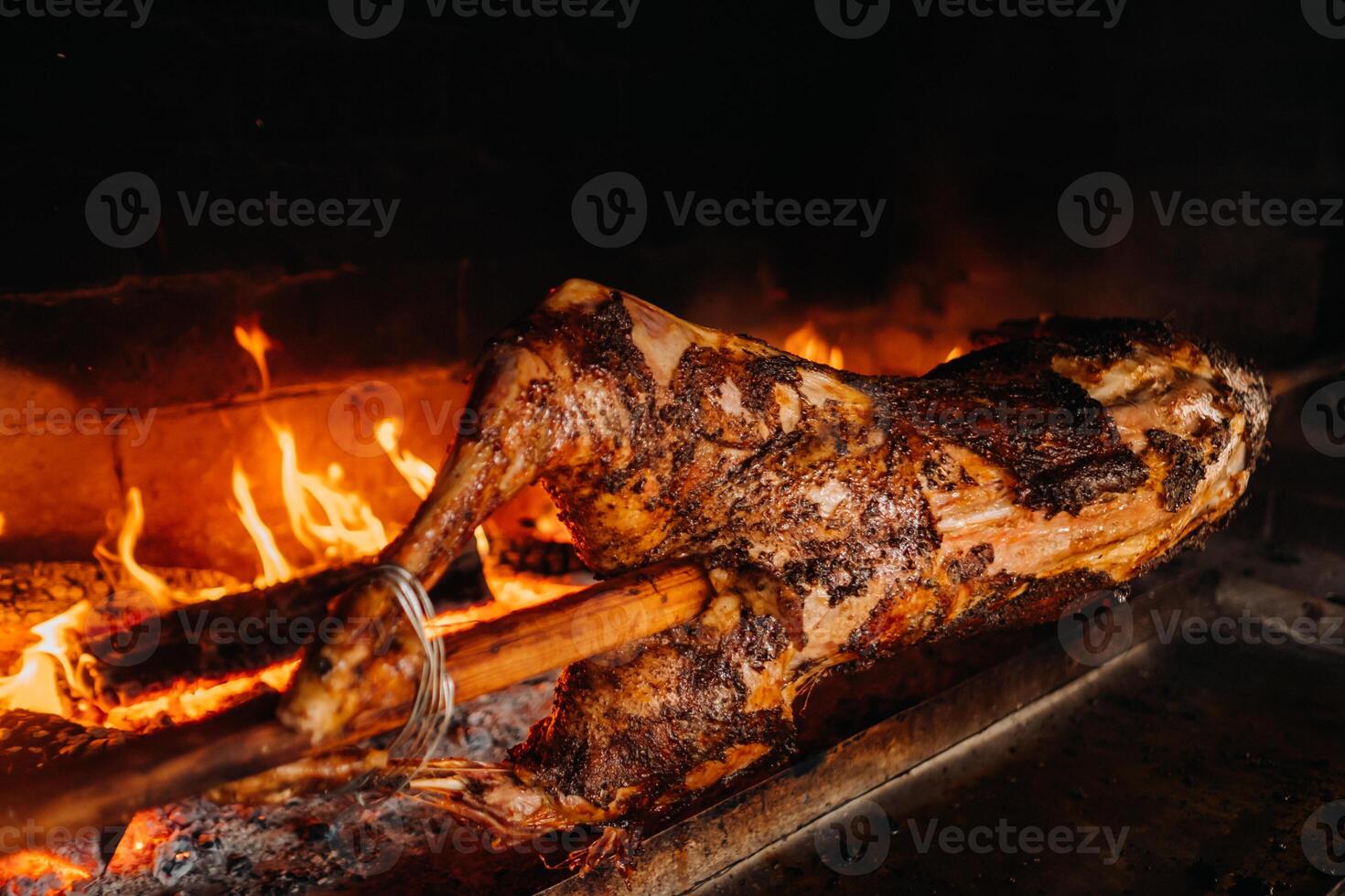 The lamb is cooked entirely on a spit on the fire. Cooking photo