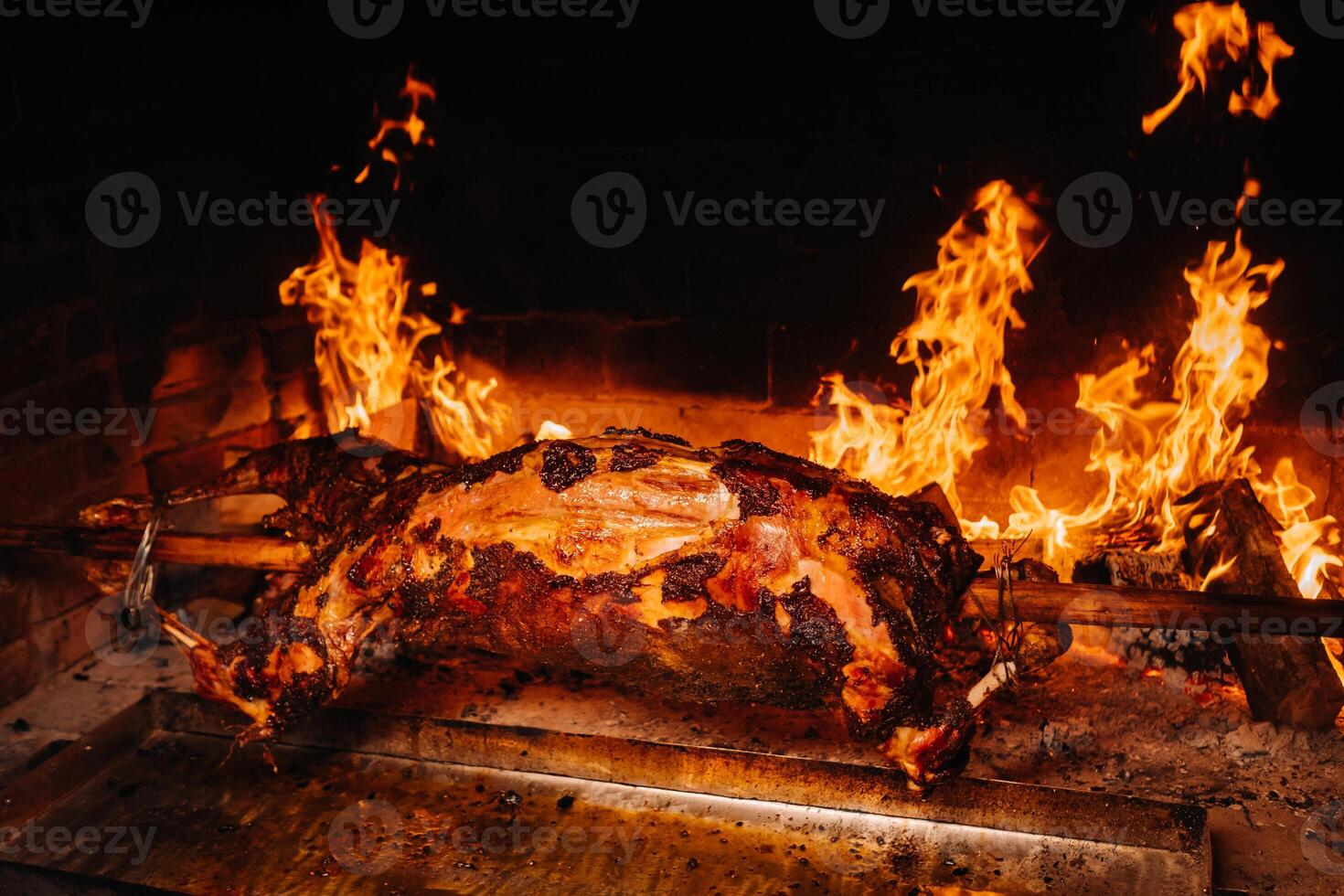 The lamb is cooked entirely on a spit on the fire. Cooking photo