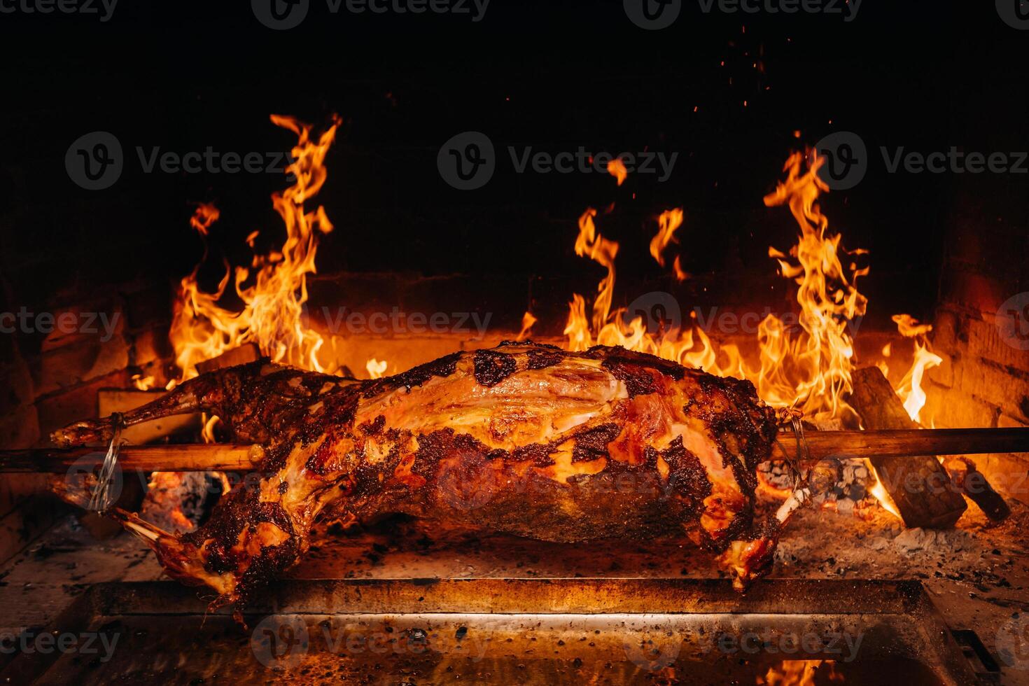 The lamb is cooked entirely on a spit on the fire. Cooking photo