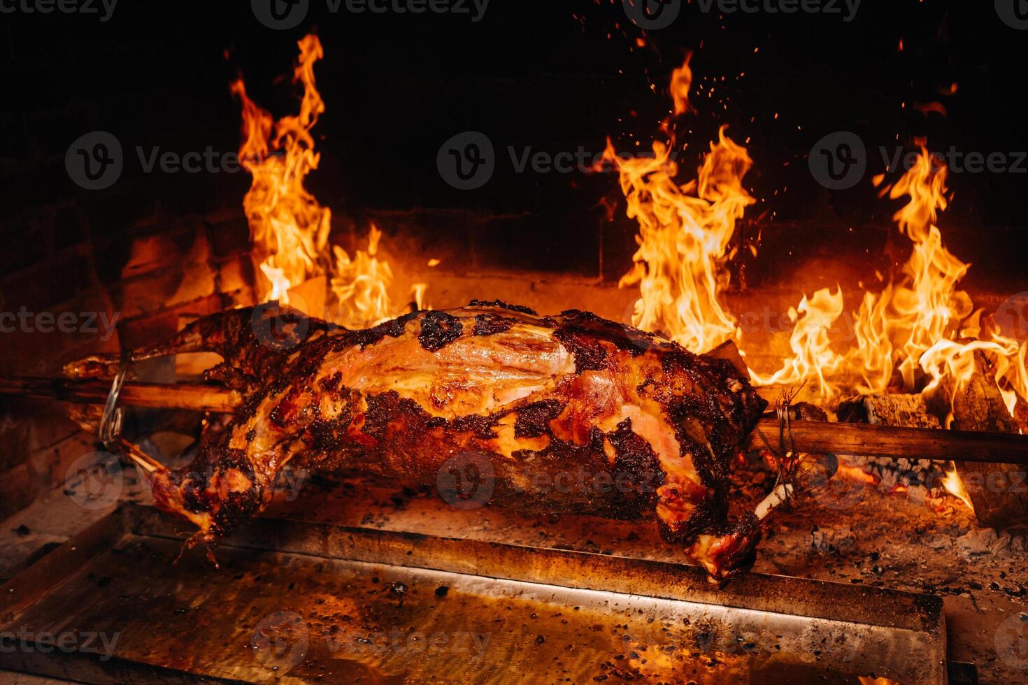 The lamb is cooked entirely on a spit on the fire. Cooking photo
