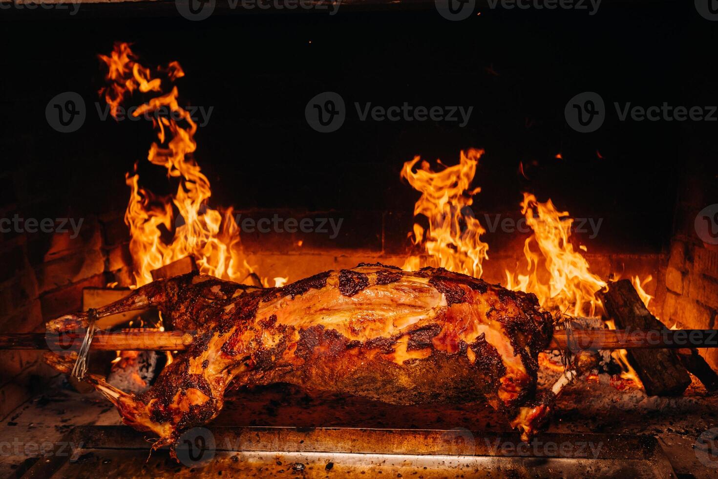 The lamb is cooked entirely on a spit on the fire. Cooking photo