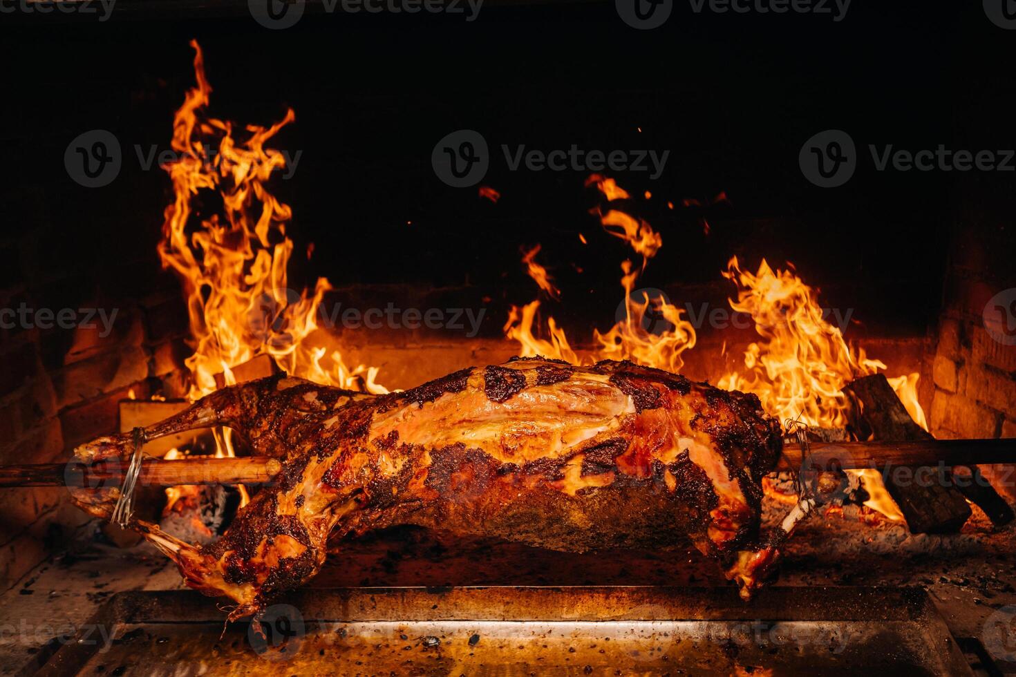 The lamb is cooked entirely on a spit on the fire. Cooking photo