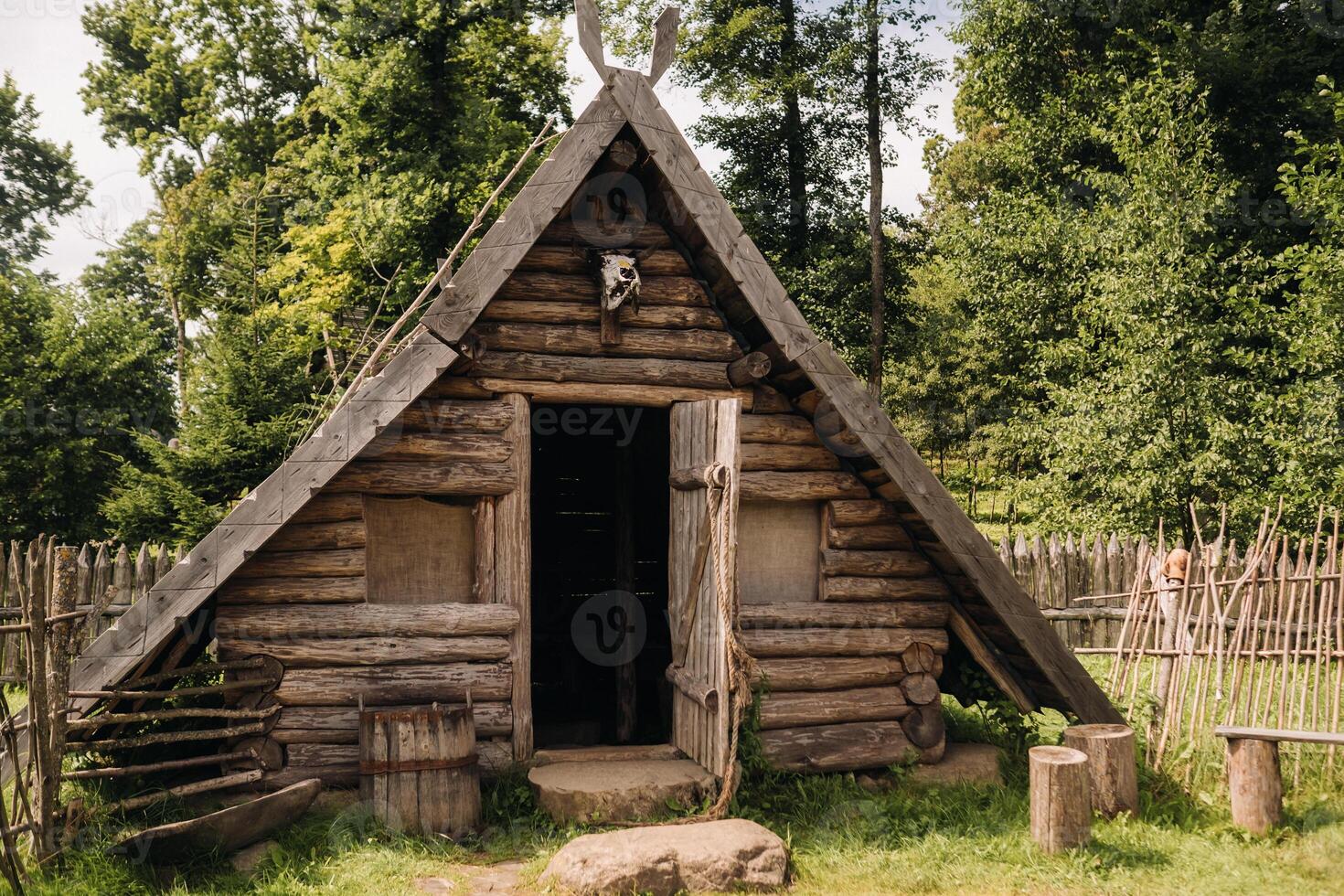 Triangular log houses with wooden roofs behind a fence. Montenegro, north photo