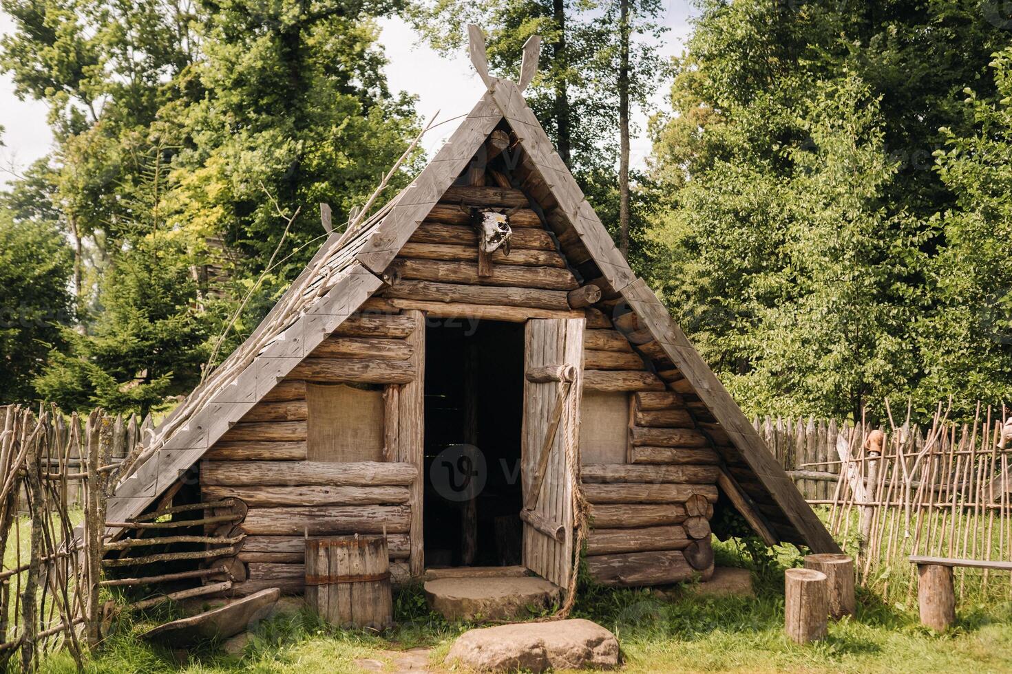 Triangular log houses with wooden roofs behind a fence. Montenegro, north photo
