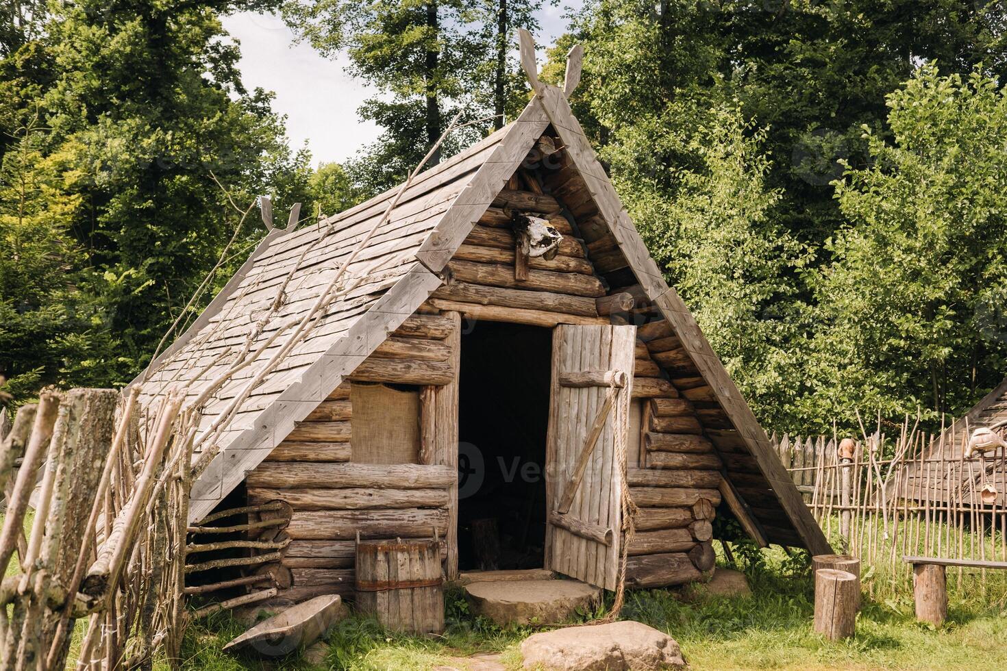 Triangular log houses with wooden roofs behind a fence. Montenegro, north photo