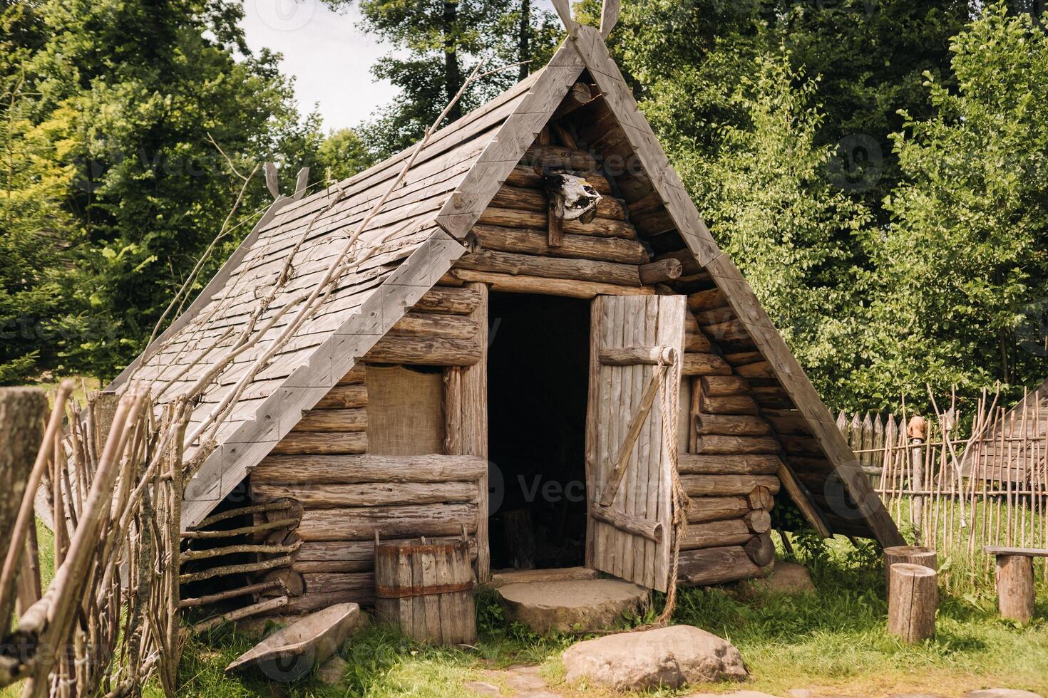 Triangular log houses with wooden roofs behind a fence. Montenegro, north photo