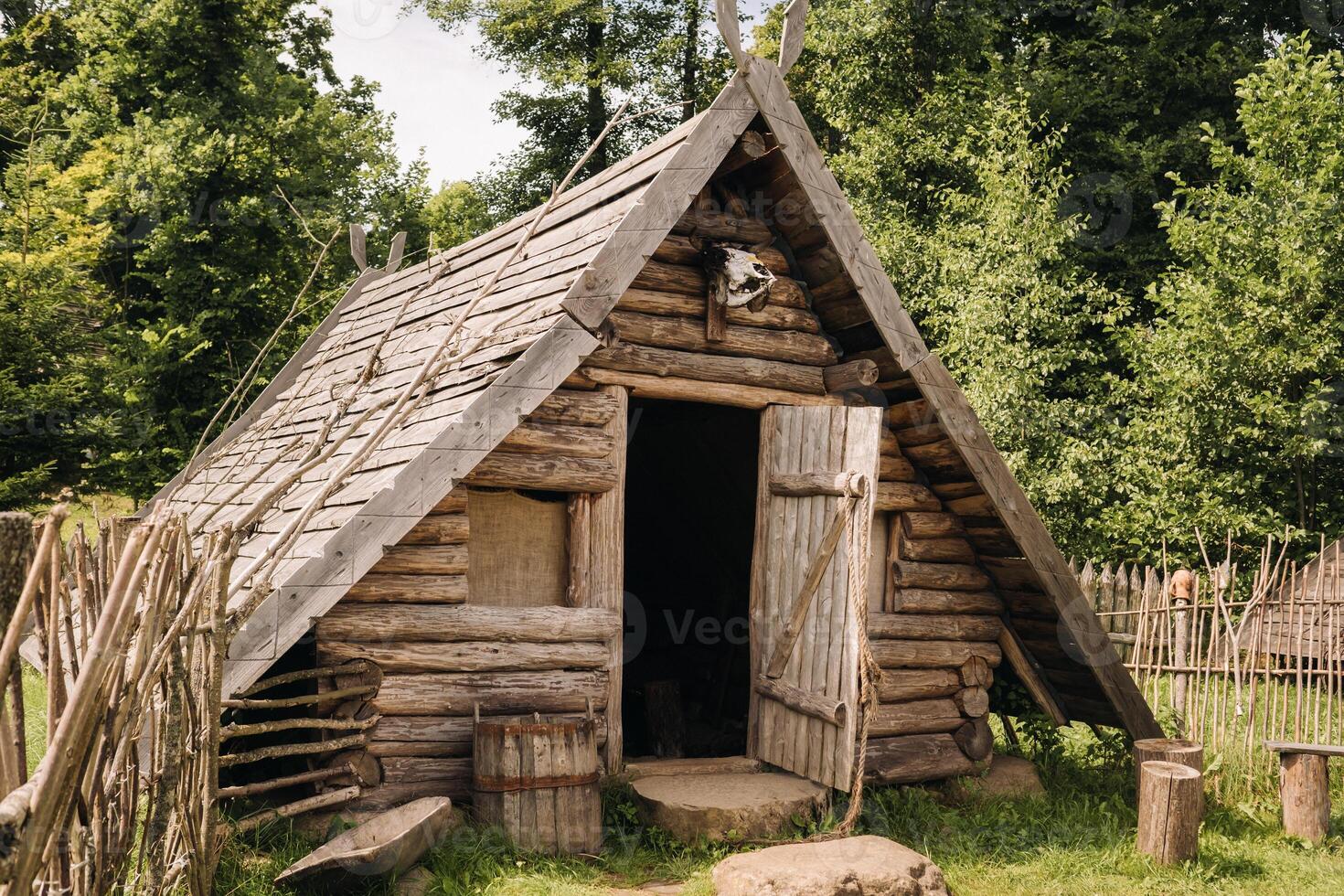 Triangular log houses with wooden roofs behind a fence. Montenegro, north photo