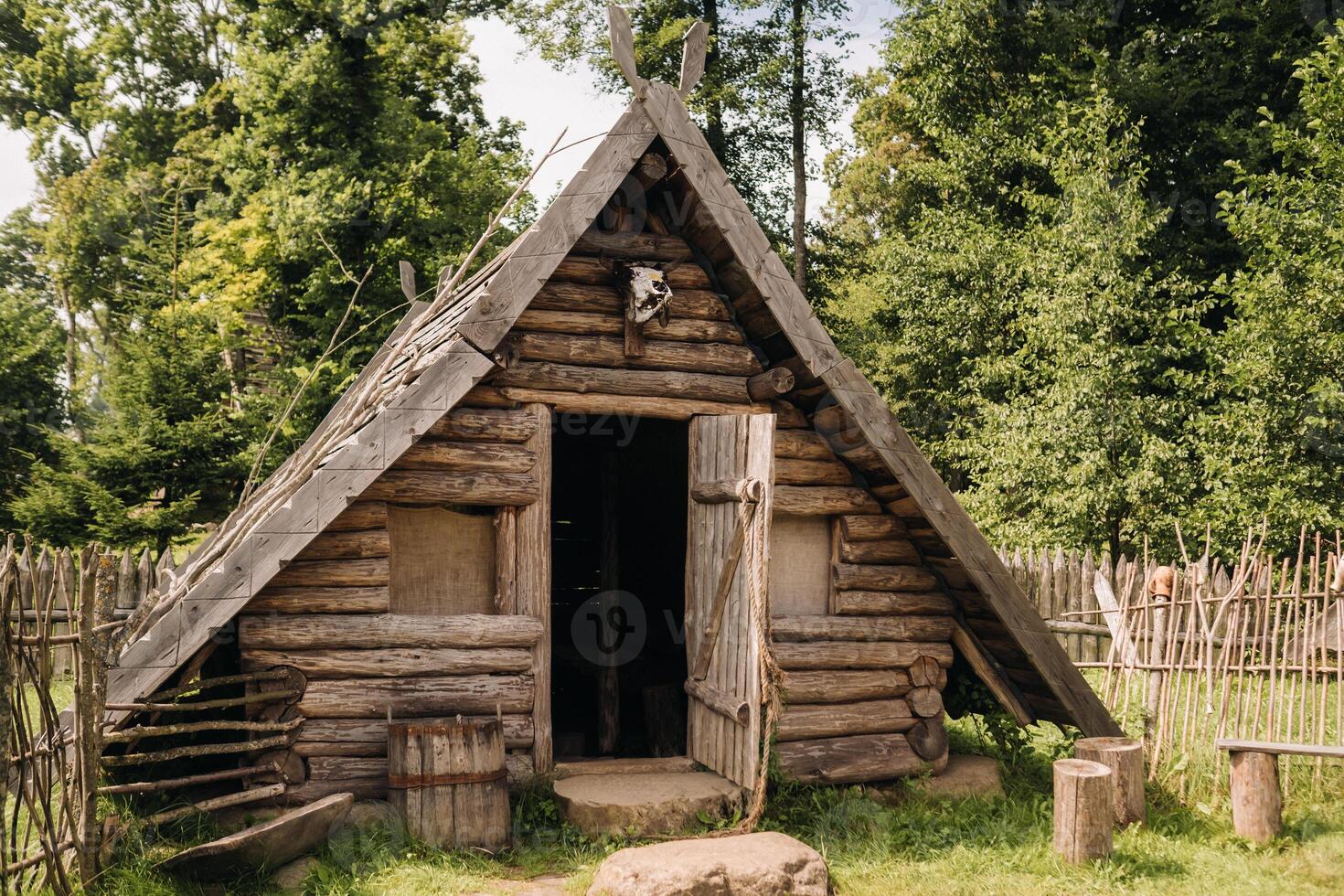 Triangular log houses with wooden roofs behind a fence. Montenegro, north photo