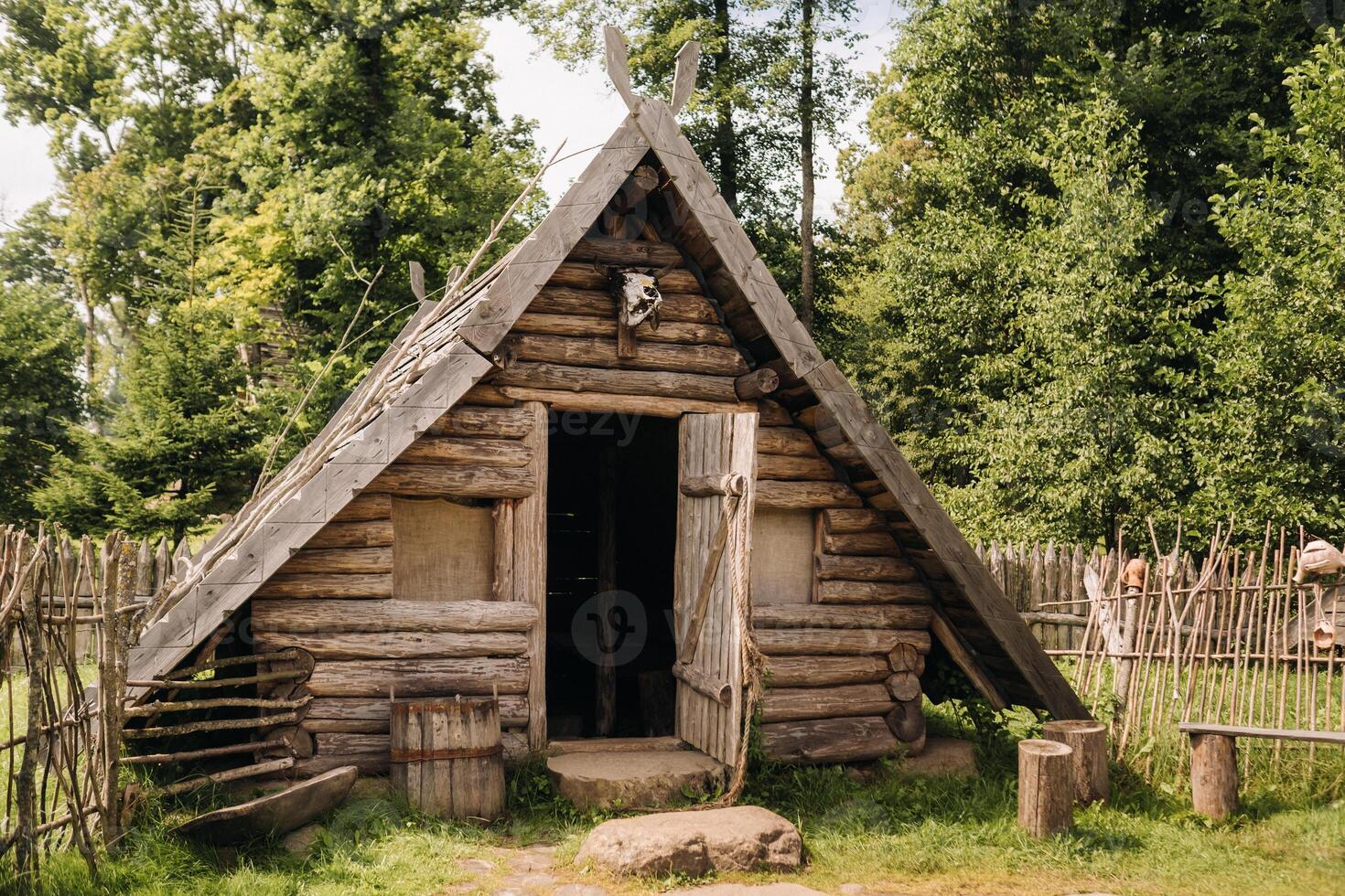 Triangular log houses with wooden roofs behind a fence. Montenegro, north photo