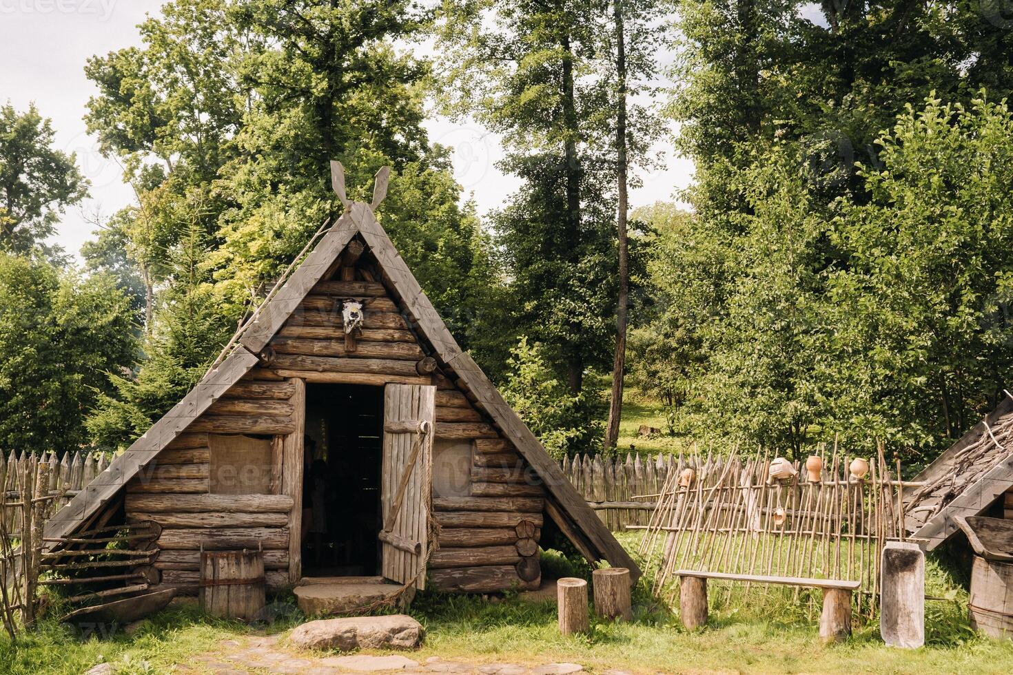 Triangular log houses with wooden roofs behind a fence. Montenegro, north photo