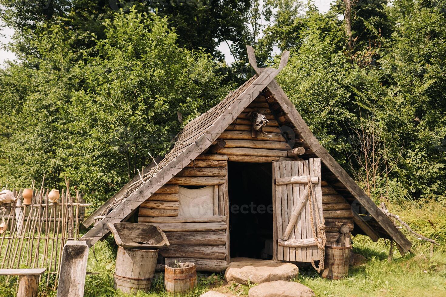 Triangular log houses with wooden roofs in an old medieval village photo