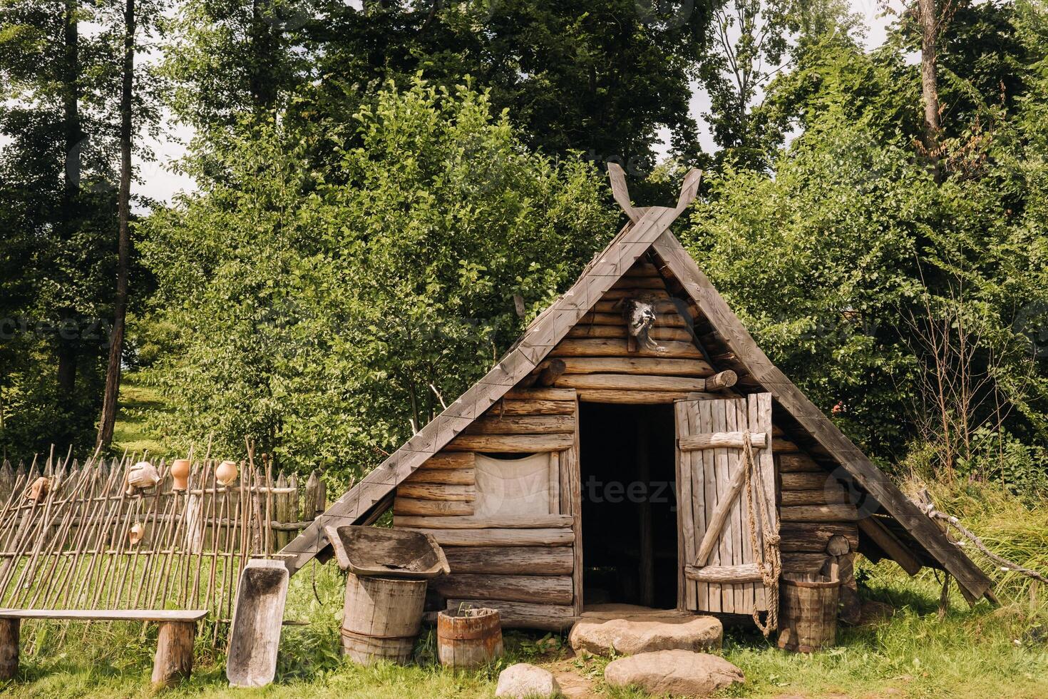 Triangular log houses with wooden roofs behind a fence. Montenegro, north photo