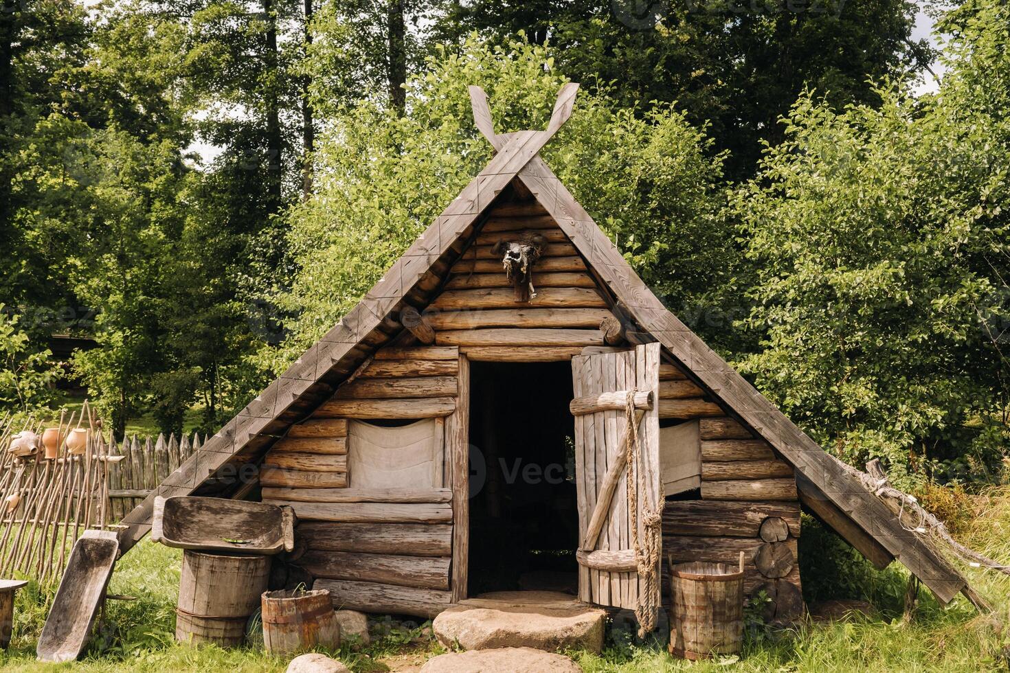 Triangular log houses with wooden roofs behind a fence. Montenegro, north photo