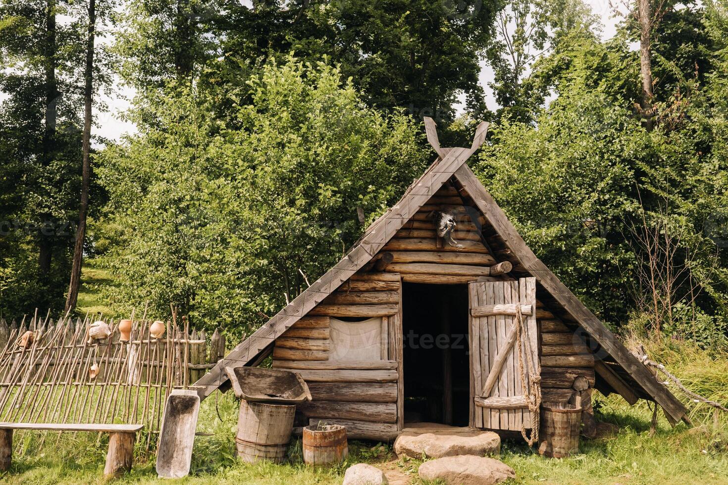 Triangular log houses with wooden roofs behind a fence. Montenegro, north photo