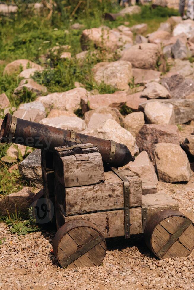 Medieval artillery piece on a wooden carriage standing outside in sunny weather photo