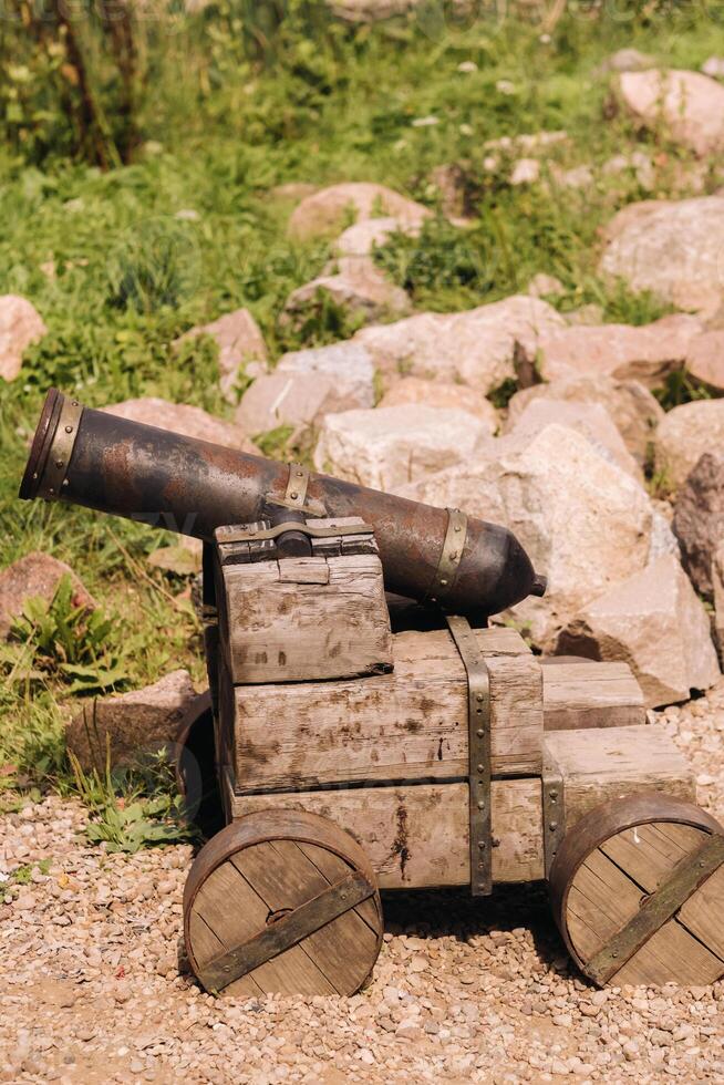 Medieval artillery piece on a wooden carriage standing outside in sunny weather photo