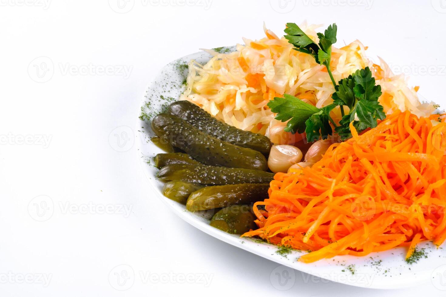 pickled vegetables, cucumber, carrot, garlic, cabbage on a plate on a white isolated background photo