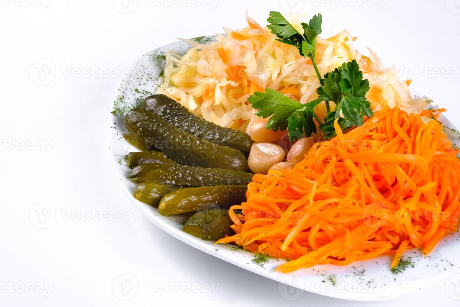 pickled vegetables, cucumber, carrot, garlic, cabbage on a plate on a white isolated background photo