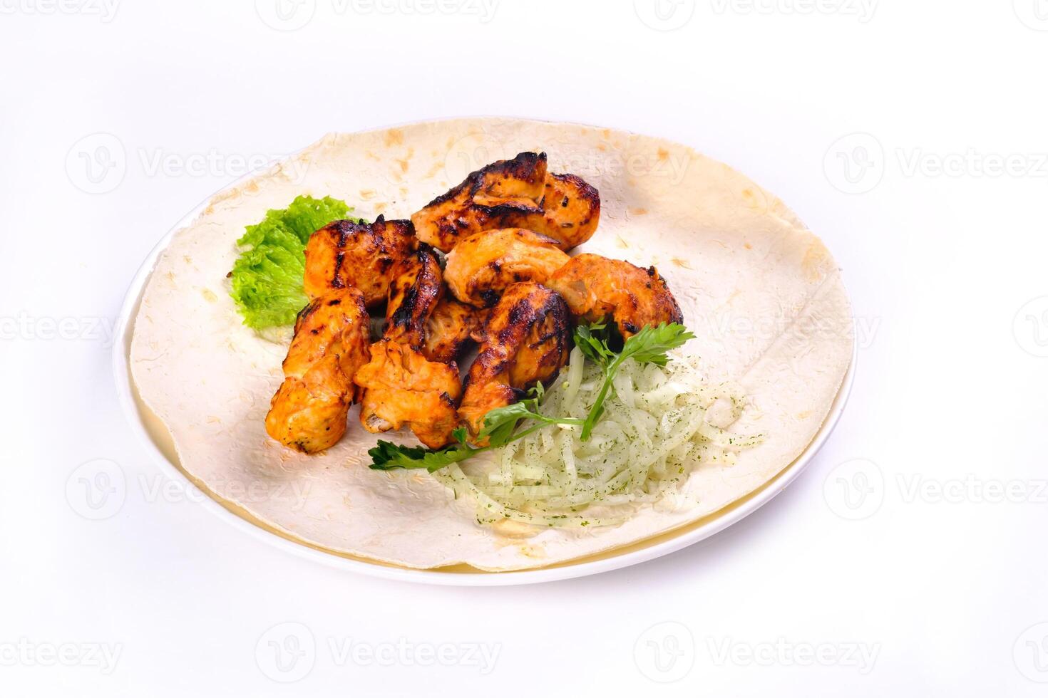 Chicken meat on pita bread with vegetables on a white plate on a white isolated background photo