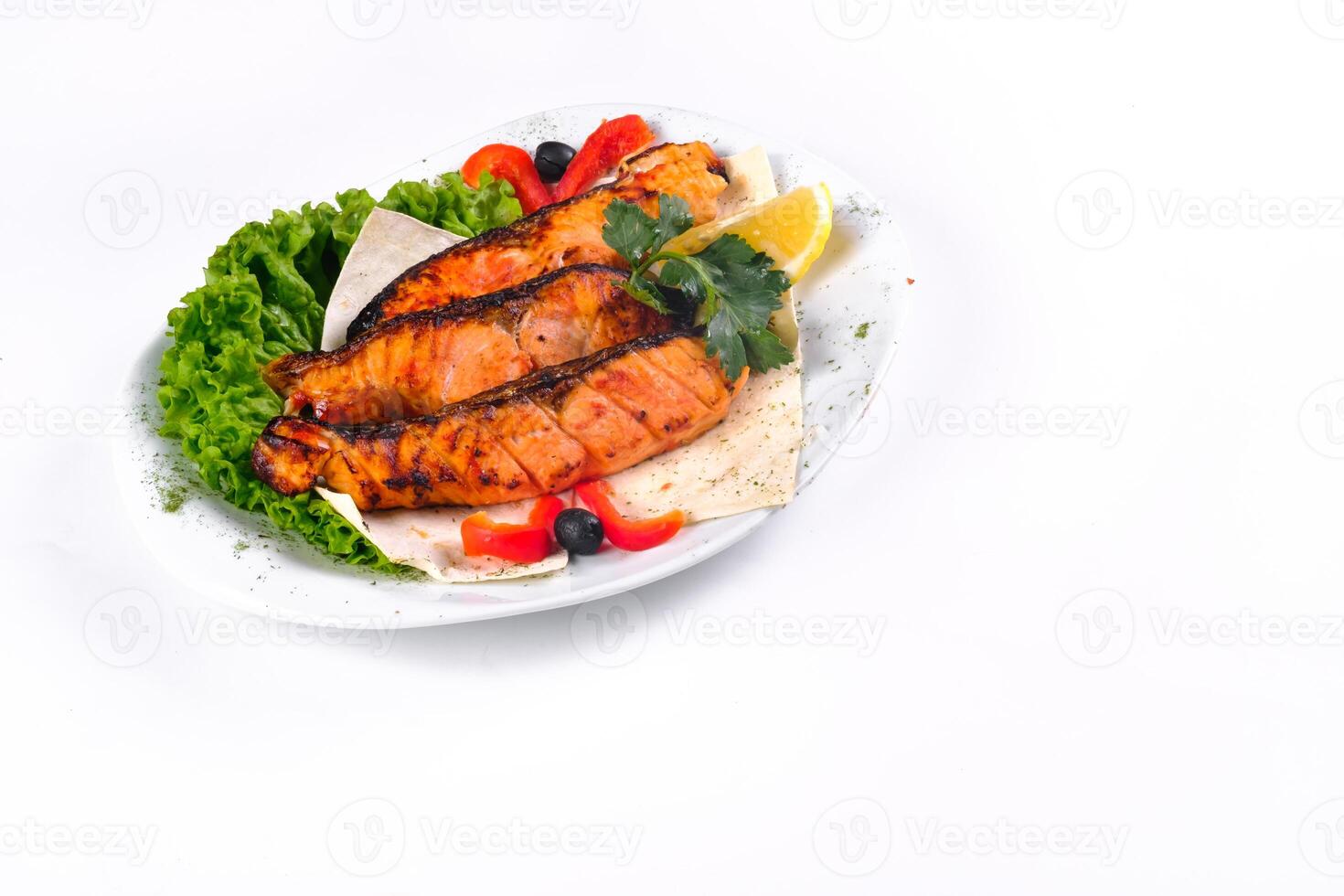 Fried fish with vegetables on a plate on a white isolated background photo
