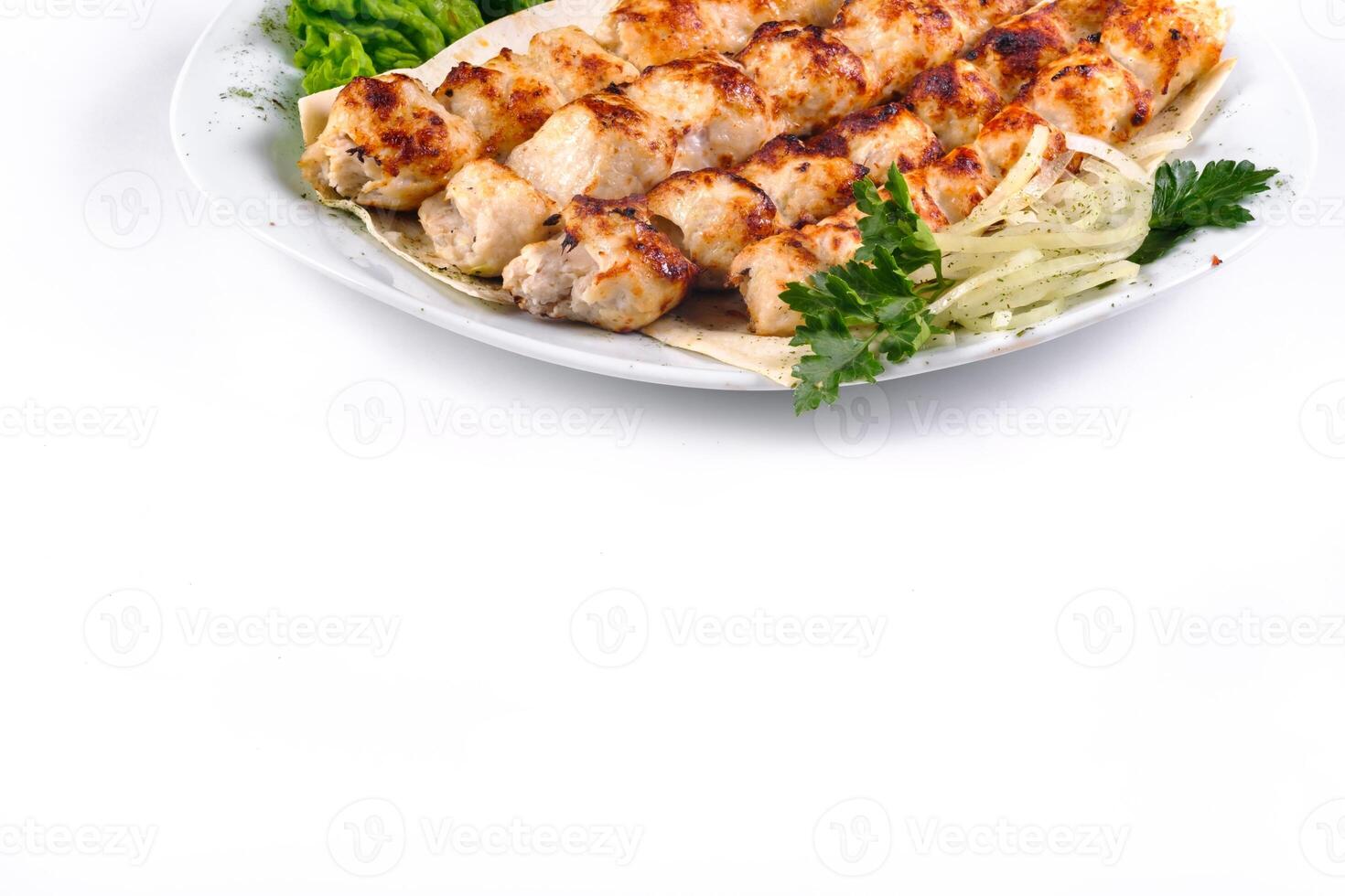 Homemade kebab on skewers with pita bread, onions, cabbage, vegetables, on a white plate on an isolated white background photo