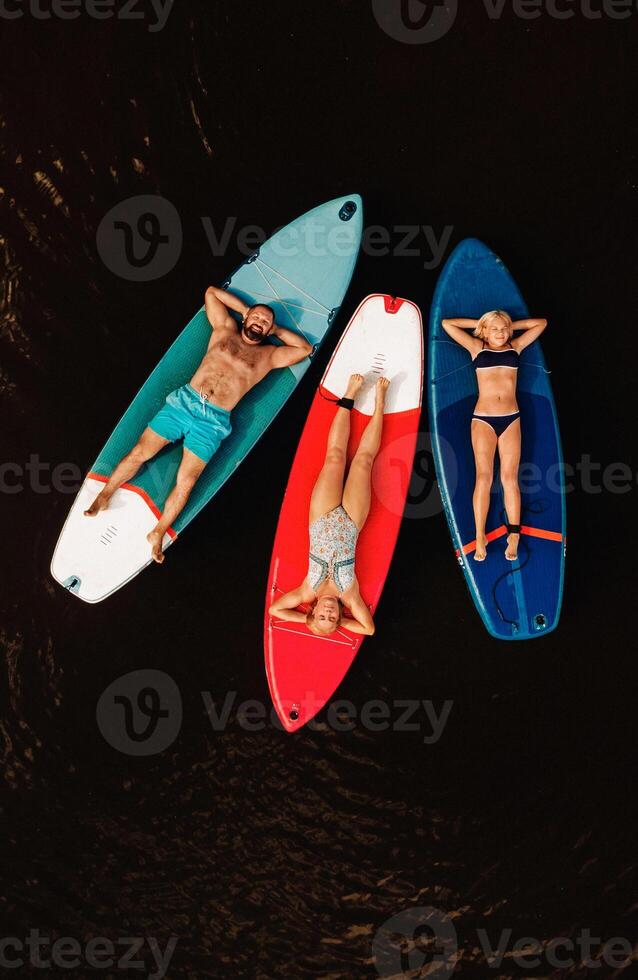 Family spend time together relaxing on sup boards on the lake photo