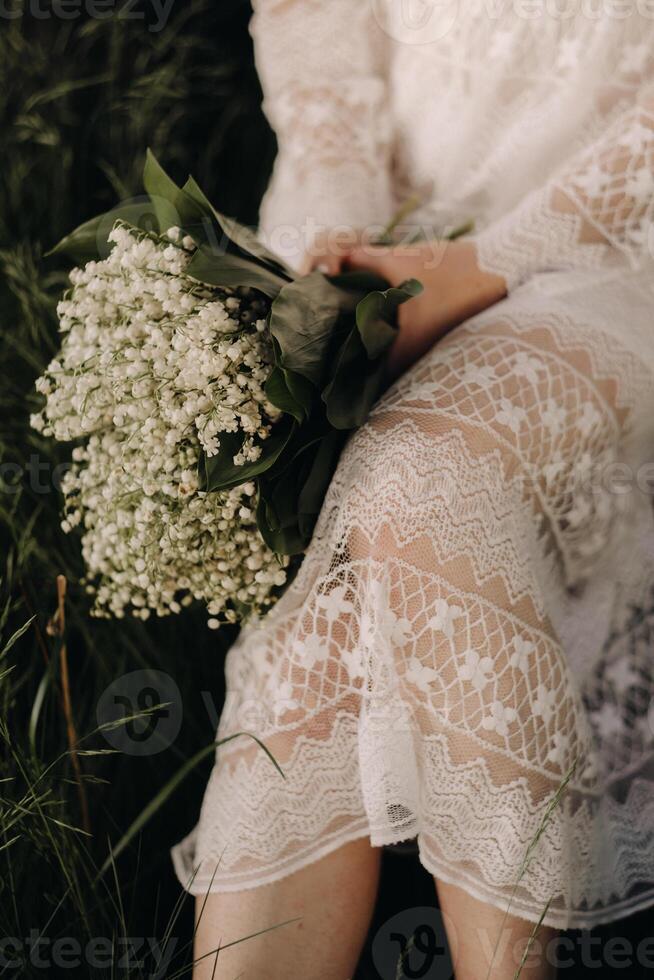 Close-up of lilies of the valley holding in the hands of a girl. Spring flowers photo