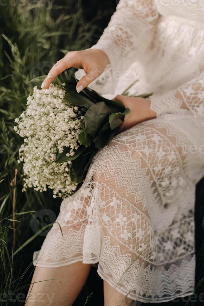 Close-up of lilies of the valley holding in the hands of a girl. Spring flowers photo
