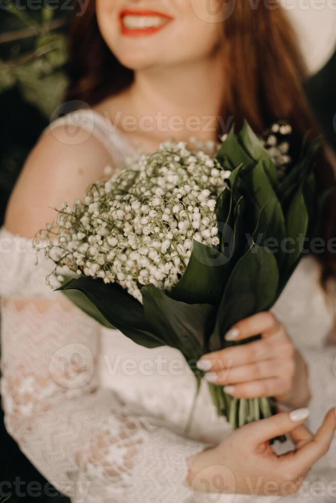 Close-up of lilies of the valley holding in the hands of a girl. Spring flowers photo