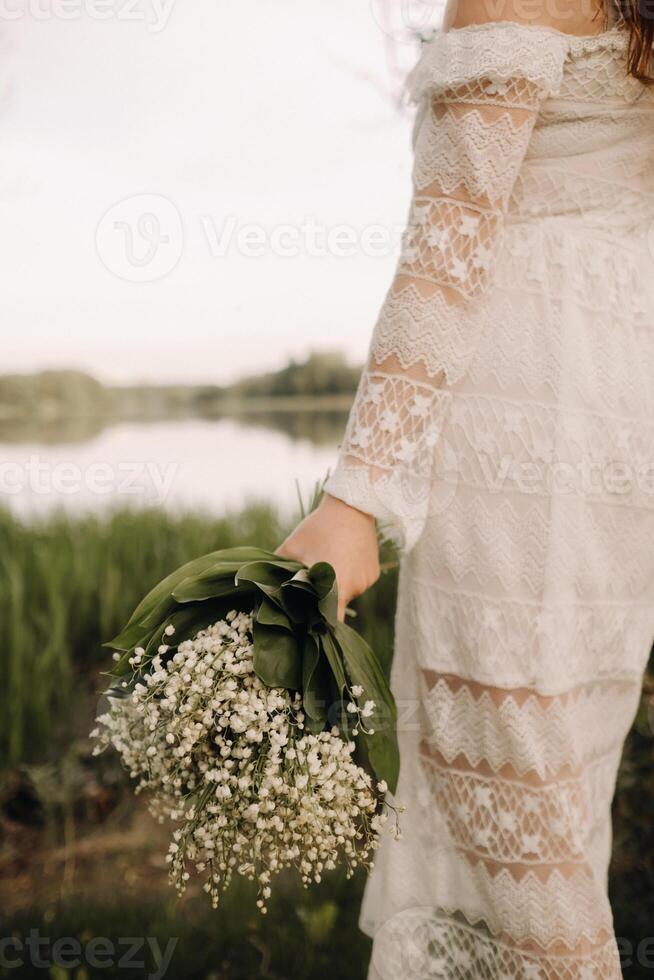 Close-up of lilies of the valley holding in the hands of a girl. Spring flowers photo