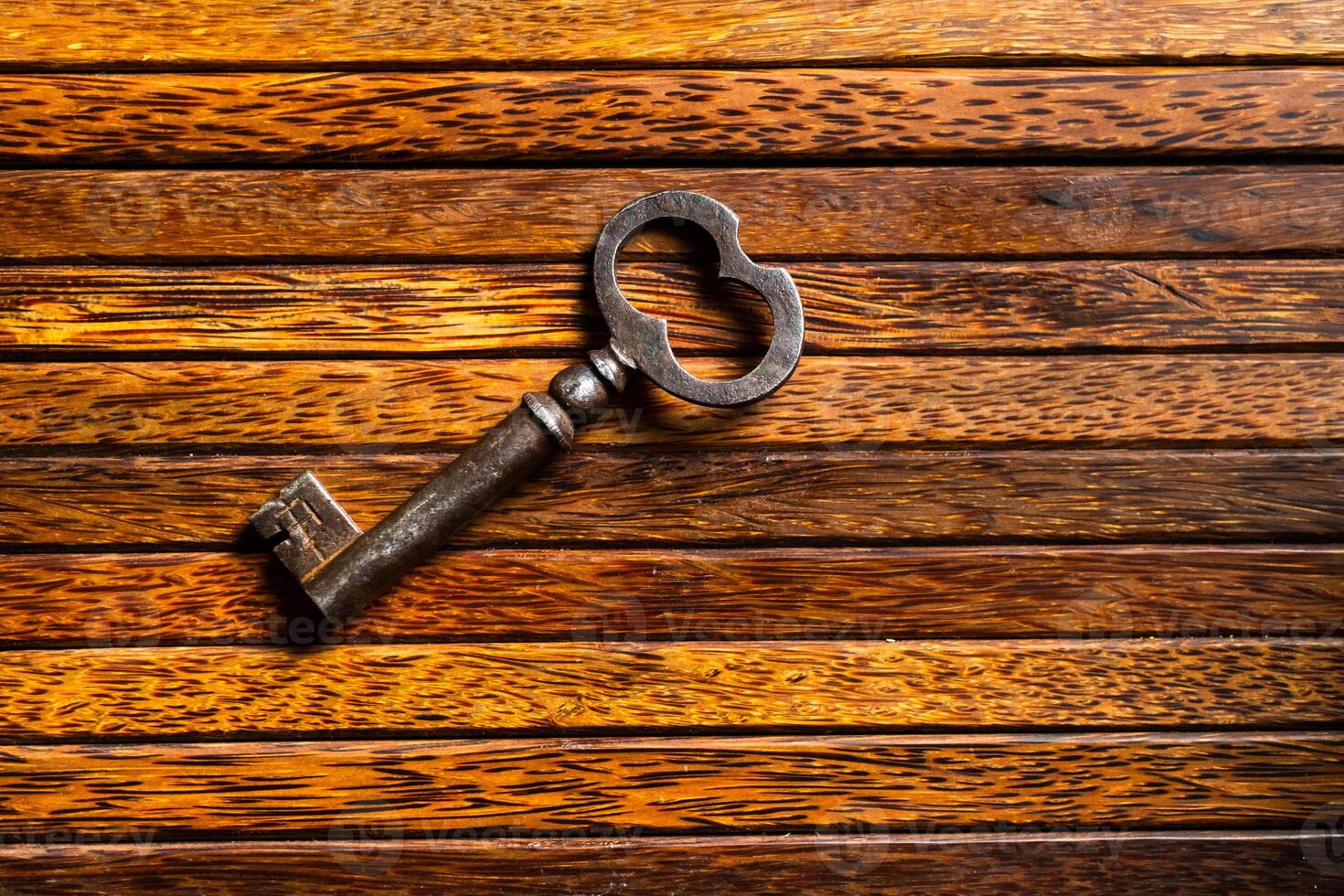 the old key lies on an old wooden table, natural textures, the concept of discoveries, secrets, answers photo