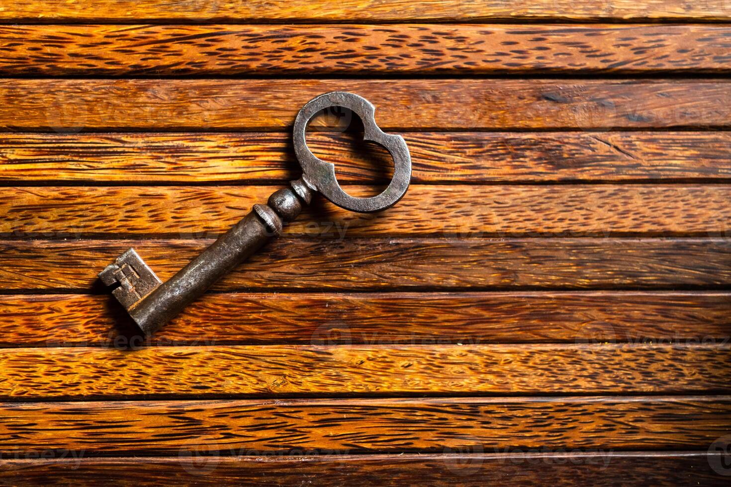 the old key lies on an old wooden table, natural textures, the concept of discoveries, secrets, answers photo