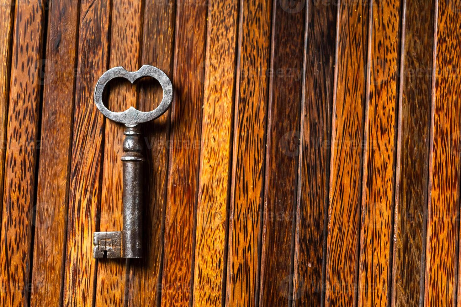 the old key lies on an old wooden table, natural textures, the concept of discoveries, secrets, answers photo