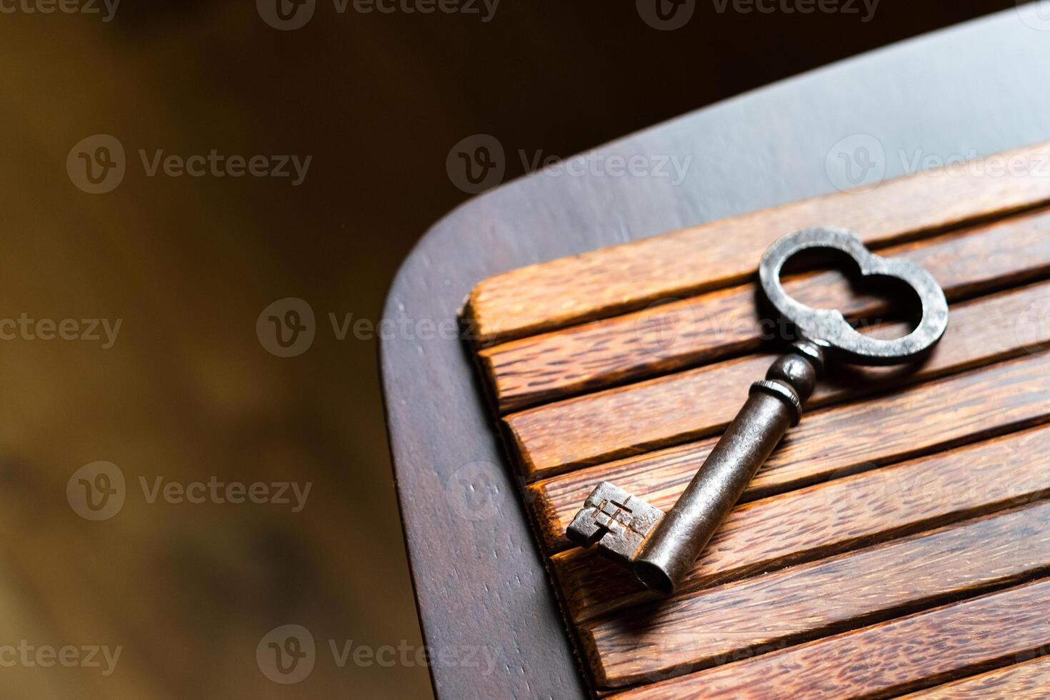 the old key lies on an old wooden table, natural textures, the concept of discoveries, secrets, answers photo